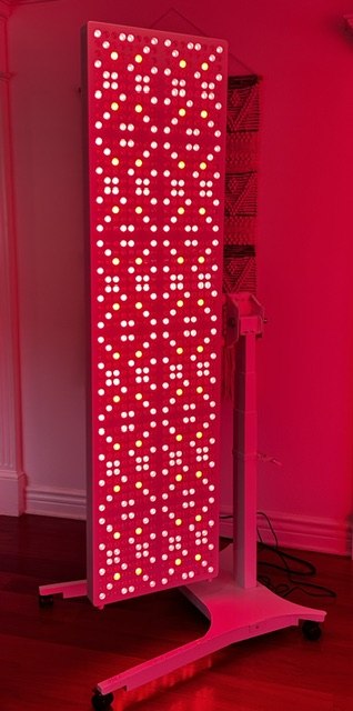 Full-body LED light therapy panel glowing red