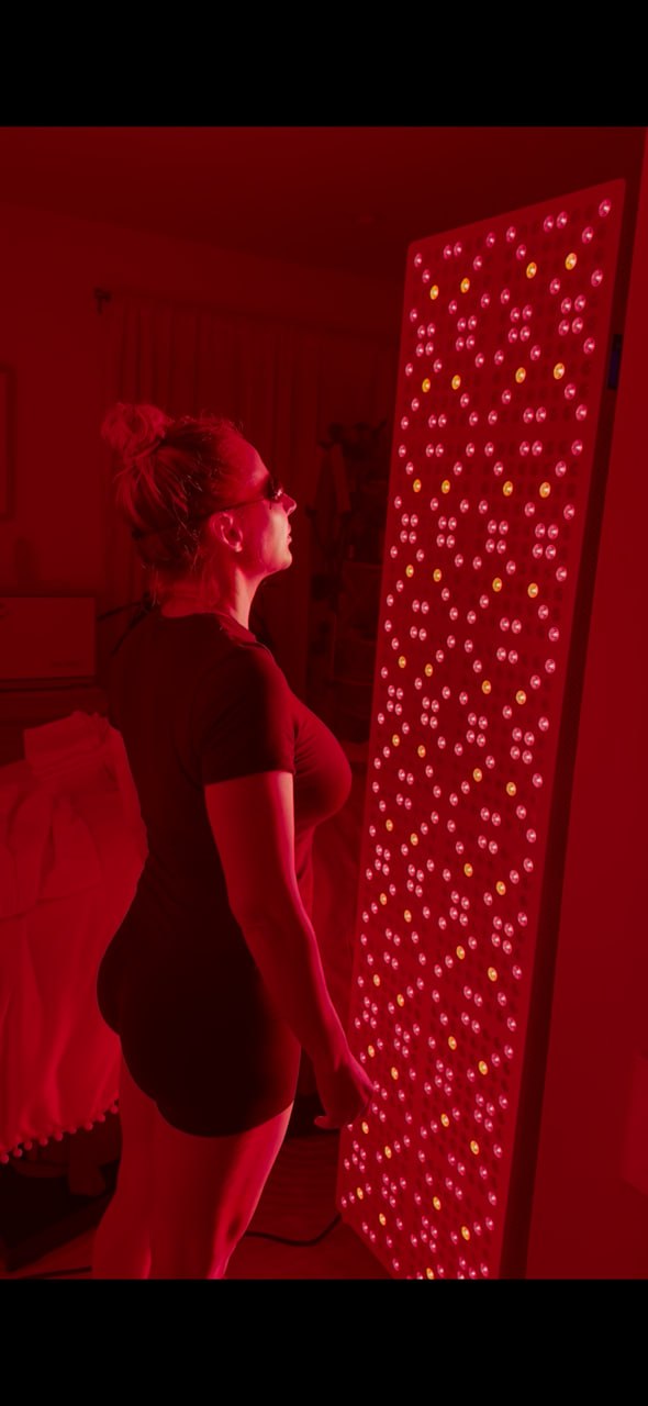 Client using the full-body LED light therapy panel